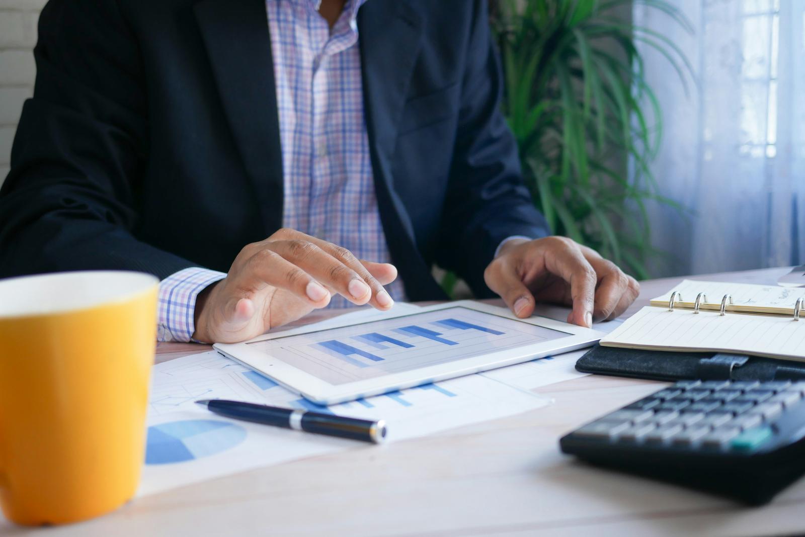 Financial charts reviewed on a tablet at a desk